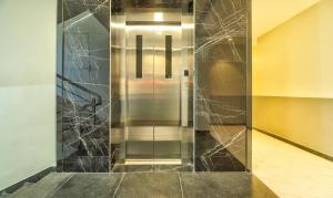 a elevator in a building with a glass door at Treebo Sriz Cozy Seethamadhara in Visakhapatnam