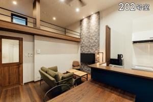 sala de estar con bar, sofá y TV en YOUR ROOM 熊本駅, en Kumamoto