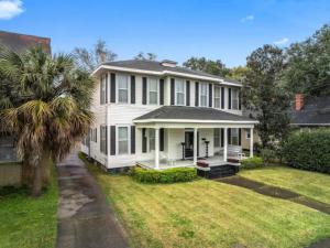 a white house with a palm tree in the yard at McKean Manor in Mobile