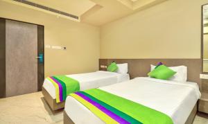 a bedroom with two beds with rainbow sheets at Treebo Trend Sriz Cozy Seethamadhara in Visakhapatnam