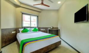 a bedroom with a large bed with a flat screen tv at Treebo Sriz Cozy Seethamadhara in Visakhapatnam