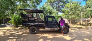 Jungle river humbhaha hostel في كاتاراغاما: رجل يقف أمام سيارة جيب سوداء
