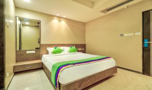 a bedroom with a large bed with a large mirror at Treebo Sriz Cozy Seethamadhara in Visakhapatnam +21 photos