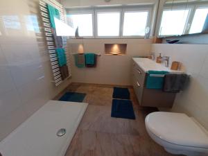 a bathroom with a toilet and a sink and a tub at BodenSEE Apartment Langenargen Möwenweg in Langenargen +19 photos