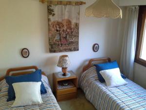 a bedroom with two beds and a picture on the wall at Buenos Aires 2525 in Mar del Plata