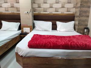 a bedroom with two beds with a red blanket at Hotel Al Sharif Manzil 90 Mtrs from Dargah in Ajmer