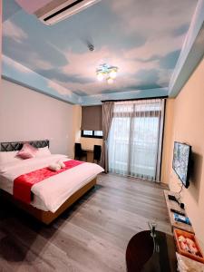 a bedroom with a bed and a television in it at 62 House in Hualien City