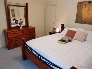 a bedroom with a bed and a dresser and a mirror at Across the road from the best Pub in Kalgoorlie!!! in Kalgoorlie