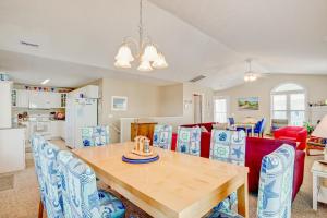 a kitchen and dining room with a wooden table and chairs at Happy Together in Holden Beach