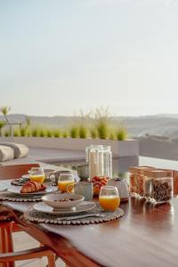 a table with food and glasses of orange juice at Luxury Ocean View Villas with Private Cook and Free Gym Membership in Kuta Lombok