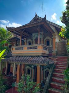 Una casa antigua con un balcón encima. en Kajeng Bungalow, en Ubud