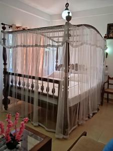 a canopy bed with curtains in a room at Hotel Dolphin Hikkaduwa in Hikkaduwa