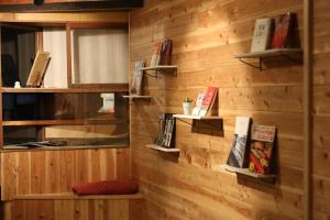 una pared de madera con estanterías y libros. en Asobigokoro - Vacation STAY 03618v, en Aso