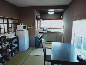 una pequeña cocina con mesa y nevera en Asobigokoro - Vacation STAY 03618v, en Aso