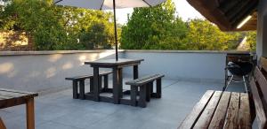 a table and benches with an umbrella on a patio at Pomegranate Selfcatering apartment in Nelspruit