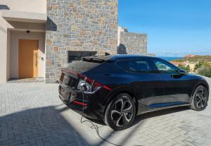 a black car parked in front of a building at Ligaria Mare in Agia Pelagia