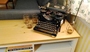 einen Schreibtisch mit Brille und eine altmodische Schreibmaschine in der Unterkunft Schwedentraum Varpstugan in Kisa