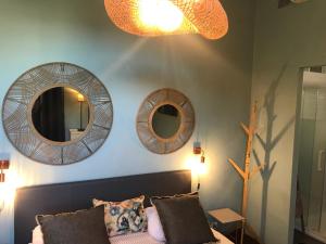 3 Spiegel an der Wand eines Zimmers mit Sofa in der Unterkunft Chambre Vinc in Bastia