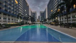 a large swimming pool in the middle of a building at Sea Residences by EZ Stay in Manila