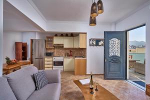 a living room with a blue door and a kitchen at Al Centro Pigadia-Althea Homes in Karpathos Town