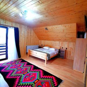 a bedroom with a bed in a wooden cabin at Pensiunea Casa Petran in Breb