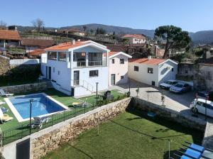 a house with a swimming pool and a yard at Areias Village in Vale de Cambra