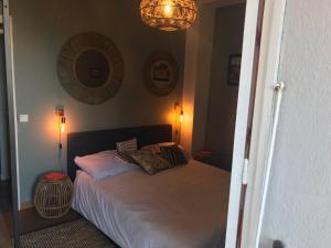 um quarto com uma cama e um lustre em Chambre Rose em Bastia