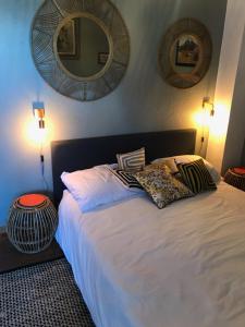 a bedroom with a large white bed with two mirrors at Chambre Rose in Bastia