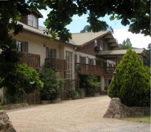 ein großes Haus mit einer Veranda und einer Auffahrt in der Unterkunft Bright Chalet in Bright