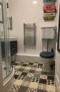 uma casa de banho com WC e azulejos pretos e brancos. em Dunes View - Atlantic Bay em Perranporth