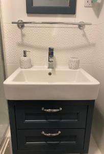 a bathroom sink with a black cabinet underneath it at Dunes View - Atlantic Bay in Perranporth