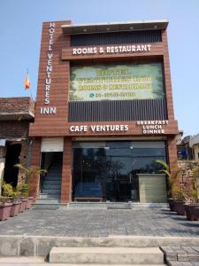 a building with a sign that reads rooms and restaurant at Hotel Ventures Inn in Amritsar