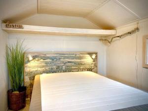ein Schlafzimmer mit einem Bett in einem Zimmer mit einer Wand in der Unterkunft Dancamps Holmsland in Hvide Sande