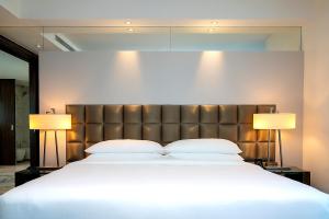 voco - Bonnington Dubai, an IHG Hotel في دبي: غرفة نوم بسرير كبير فيها مصباحين