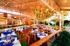 un restaurant avec des tables et des chaises avec des tables bleues dans l'établissement Belconti Resort Hotel, à Belek