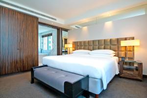 - une chambre avec un grand lit blanc et un banc dans l'établissement voco - Bonnington Dubai, an IHG Hotel, à Dubaï