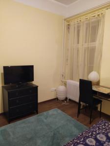um quarto com uma televisão numa cómoda e uma secretária em Napraforgó apartman Tokaj em Tokaj
