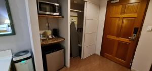 a small room with a kitchen with a microwave at Days Inn Guam - Tamuning in Tamuning