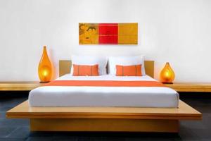 1 dormitorio con 1 cama grande con almohadas de color naranja en Bali Island Villas & Spa CHSE Certified, en Seminyak