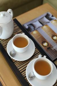 a table with two cups of tea and a tray at Bali Island Villas & Spa CHSE Certified in Seminyak