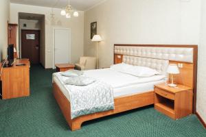 Dormitorio con cama, escritorio y TV en Hotel Aliance, en Orsk