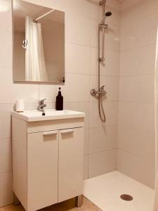 een badkamer met een wastafel en een douche met een spiegel bij Casa El Campanario in Yunquera