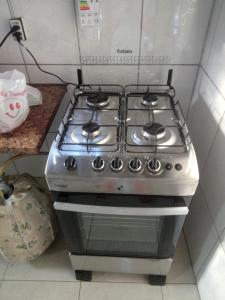 a stove top oven sitting in a kitchen at Casa 2 minutos a pé da Praia de INDAIÁ in Bertioga