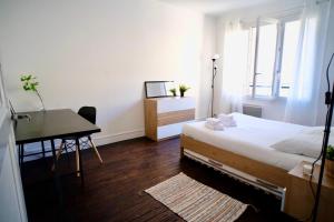 a bedroom with a bed and a desk and a table at Tour Leroy by LCDC in Caen