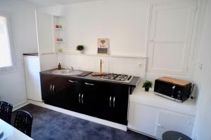 a small kitchen with a sink and a microwave at Tour Leroy by LCDC in Caen
