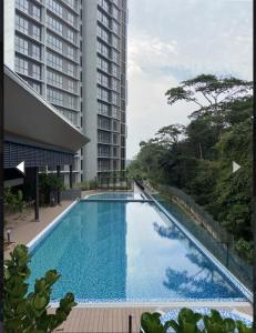 a large swimming pool next to a tall building at The clio 2 residences, beside conezion, beside ioi city mall, opposite serdang hospital, beside uniteen and UPM, Putrajaya in Putrajaya