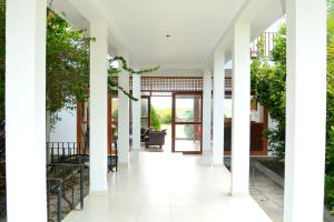 um corredor de uma casa com paredes brancas e árvores em Hotel Bundala Park View em Hambantota