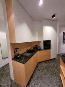 cocina con armarios blancos y encimera negra en Klettasel, en Hof