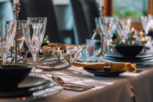 a table set with glasses and plates and silverware at Karongwe Portfolio - Kuname Lodge in Hoedspruit