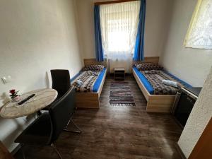 a room with two beds and a table and chairs at Gasthof Knezevic in Leoben